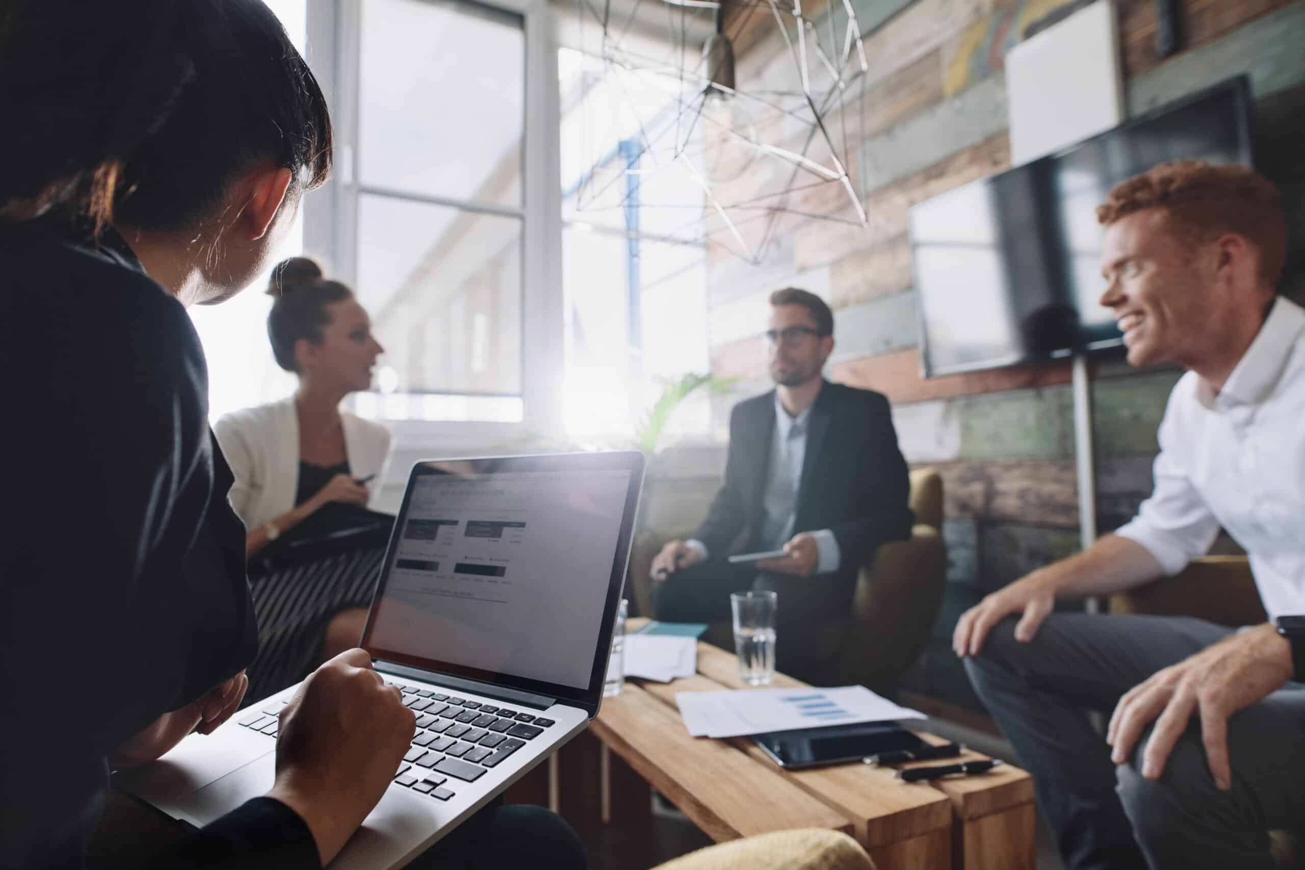 Businesswoman working on laptop in meeting about Spanish SEO
